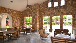 An outdoor patio area with stone walls, multiple seating arrangements, and a view of the surrounding landscape. - 431BVD (Davenport)