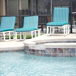 A pool area with three lounge chairs and a small hot tub. - 2636 Emerald Island Blvd (Kissimmee)