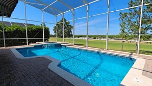 Una piscina con zona coperta e vista su un campo da golf.
