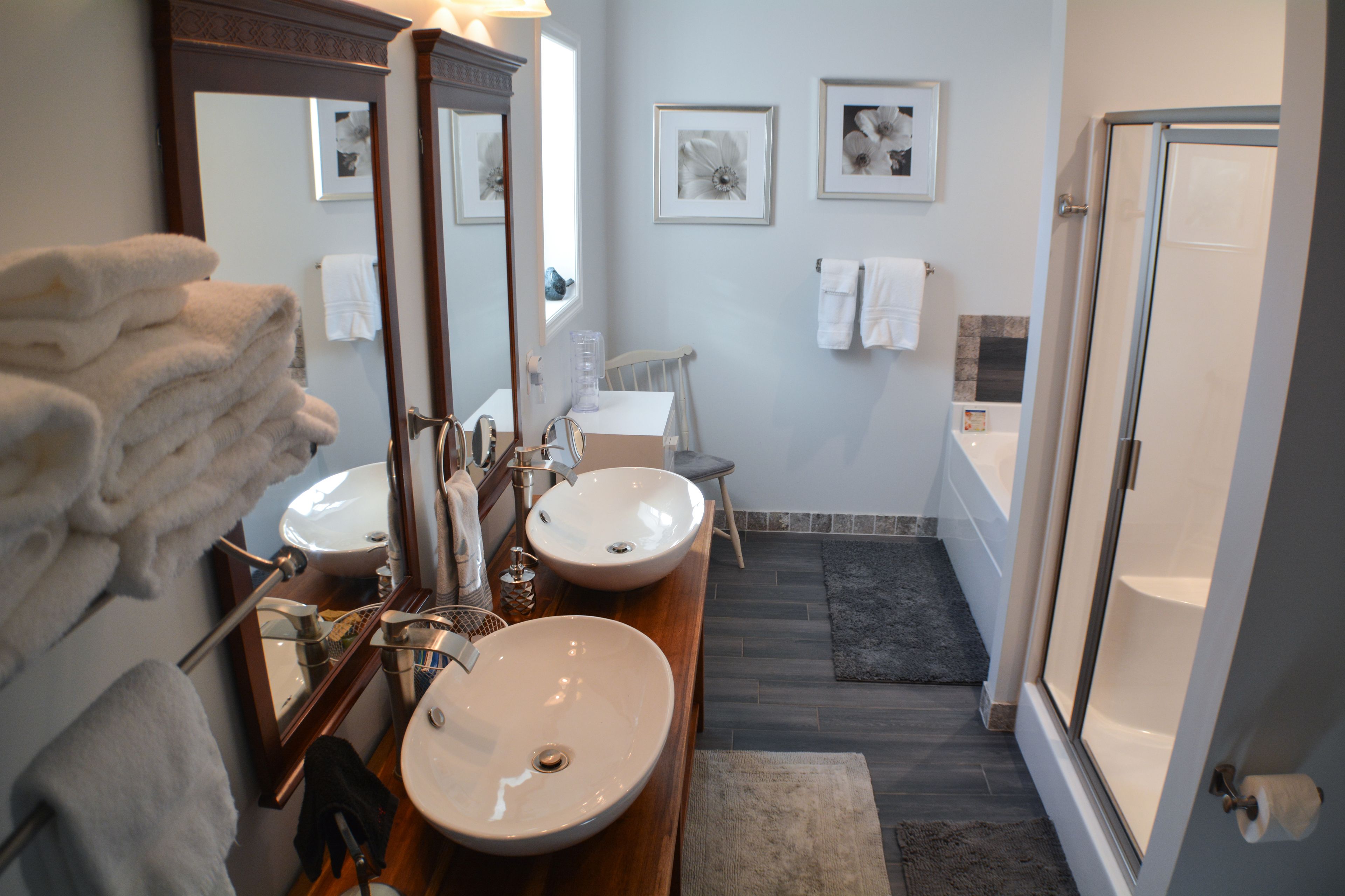 A bathroom with two sinks, a large mirror, and a shower area.