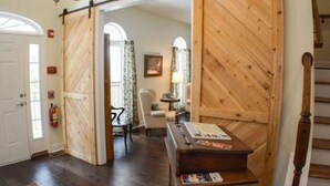 A wooden interior with a desk and chair, a door, and a staircase. - St Francis Cottage (Chattanooga)