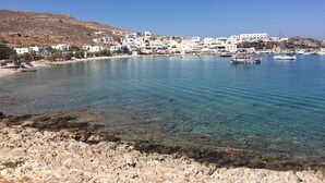 A coastal town with white buildings, clear blue water, and boats. - Amo Suites & Spa (Folegandros)