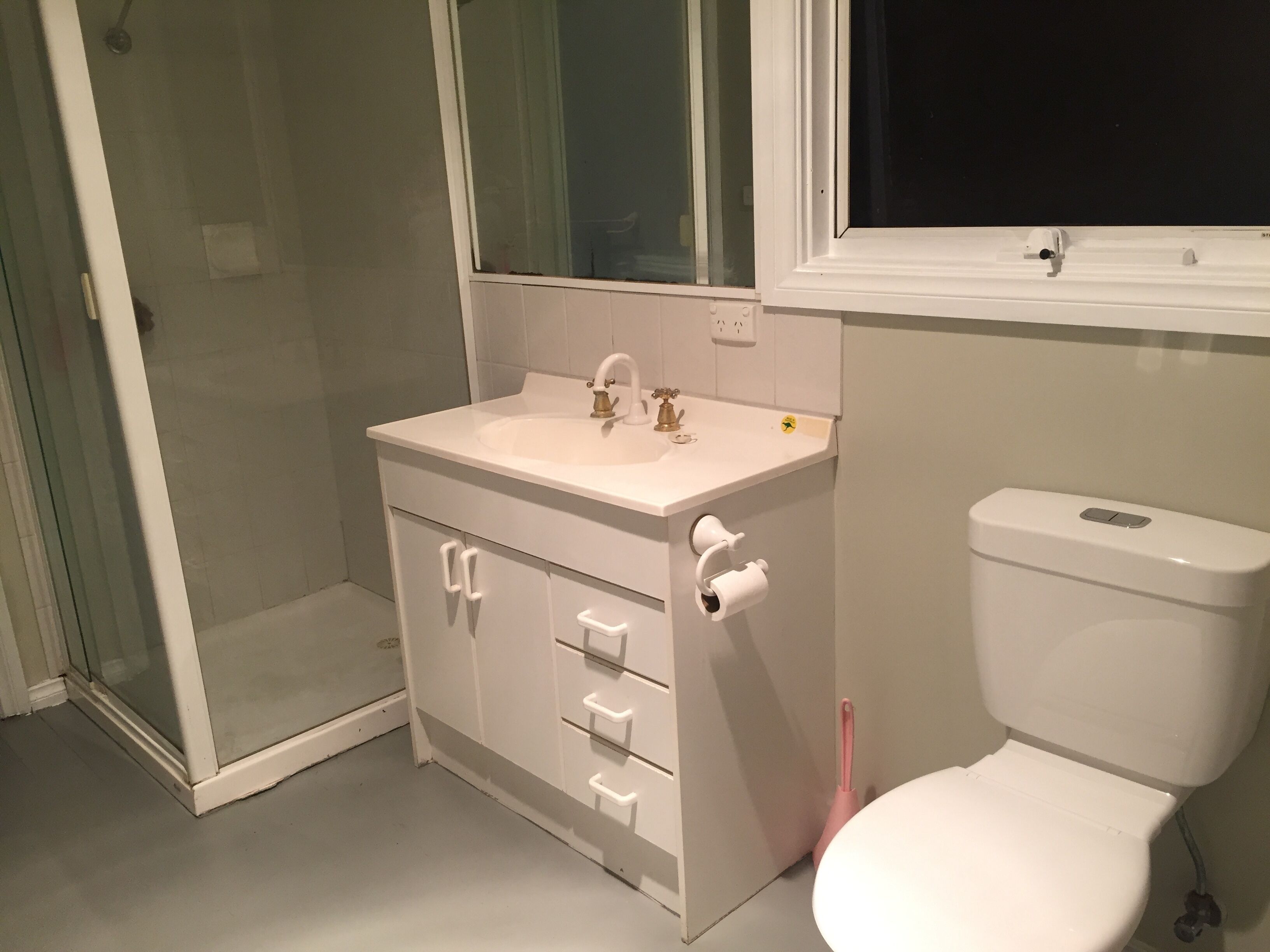 A bathroom with a white sink, a toilet, and a shower area.