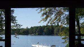 A lakeside view with a dock, a chair, and a grassy area. - Sandy waterfront, grass yard, 40' private dock. Foliage week special-Book now! (Moultonborough)
