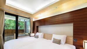 A modern hotel room with a large bed, wooden headboard, and a glass door leading to a balcony. - Hakone Suishoen (Hakone)