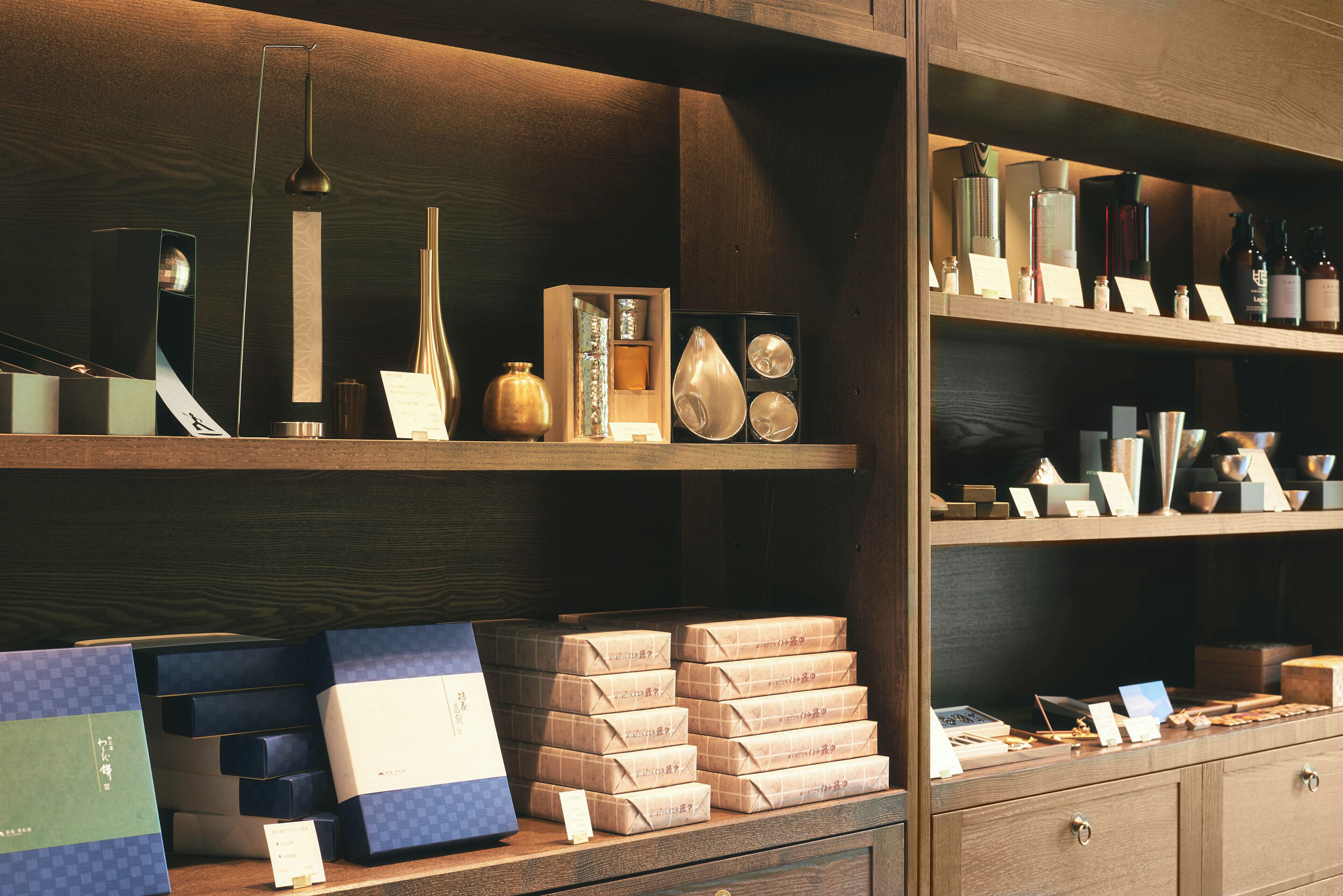 Interior de una tienda con estanterías mostrando diferentes artículos, incluyendo cajas y objetos decorativos.