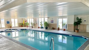 An indoor swimming pool with clear water, surrounded by potted plants and a tiled deck. - ADAGIO#207 BEAUTIFUL 3 BED/3 BATH OCEAN BLOCK CONDO W/INDOOR POOL STEPS TO BEACH (Ocean City)