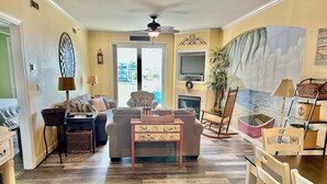 A living room with a sofa, a coffee table, a fireplace, and a television. - ADAGIO#207 BEAUTIFUL 3 BED/3 BATH OCEAN BLOCK CONDO W/INDOOR POOL STEPS TO BEACH (Ocean City)