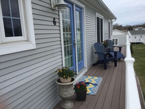 A house with a porch, a blue door, and two Adirondack chairs.