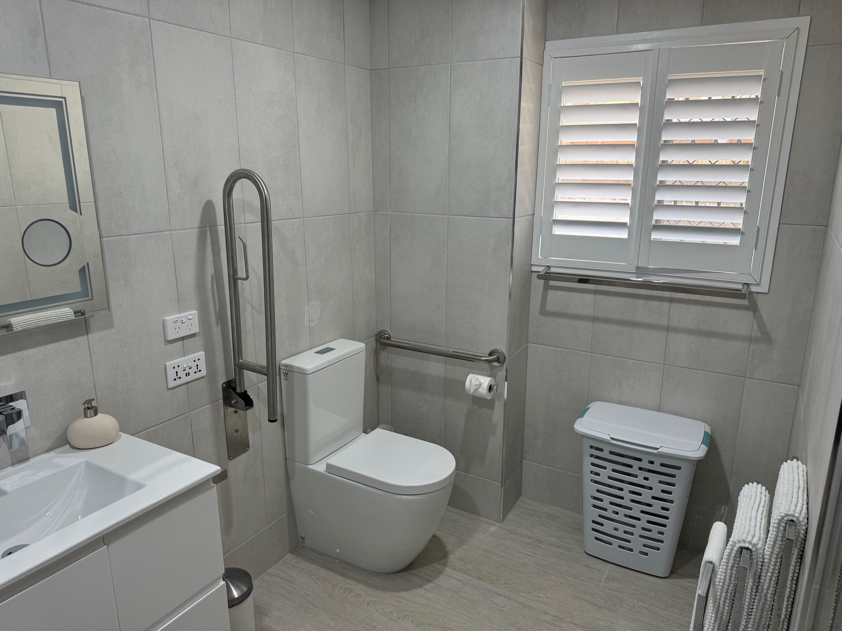 Ein modernes Badezimmer mit Toilette, Waschbecken und Dusche.