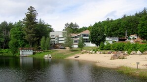 Ein See mit einer Anlegestelle, umgeben von einer Wohngegend mit Häusern und Bäumen.