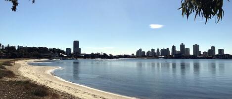 A beach with a city skyline in the background.