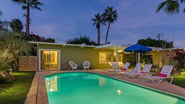 A swimming pool with lounge chairs and a covered patio area. - PS-ID #76 Stylish Mid-Century Modern Oasis with Surrounding Mountain Views (Palm Springs)