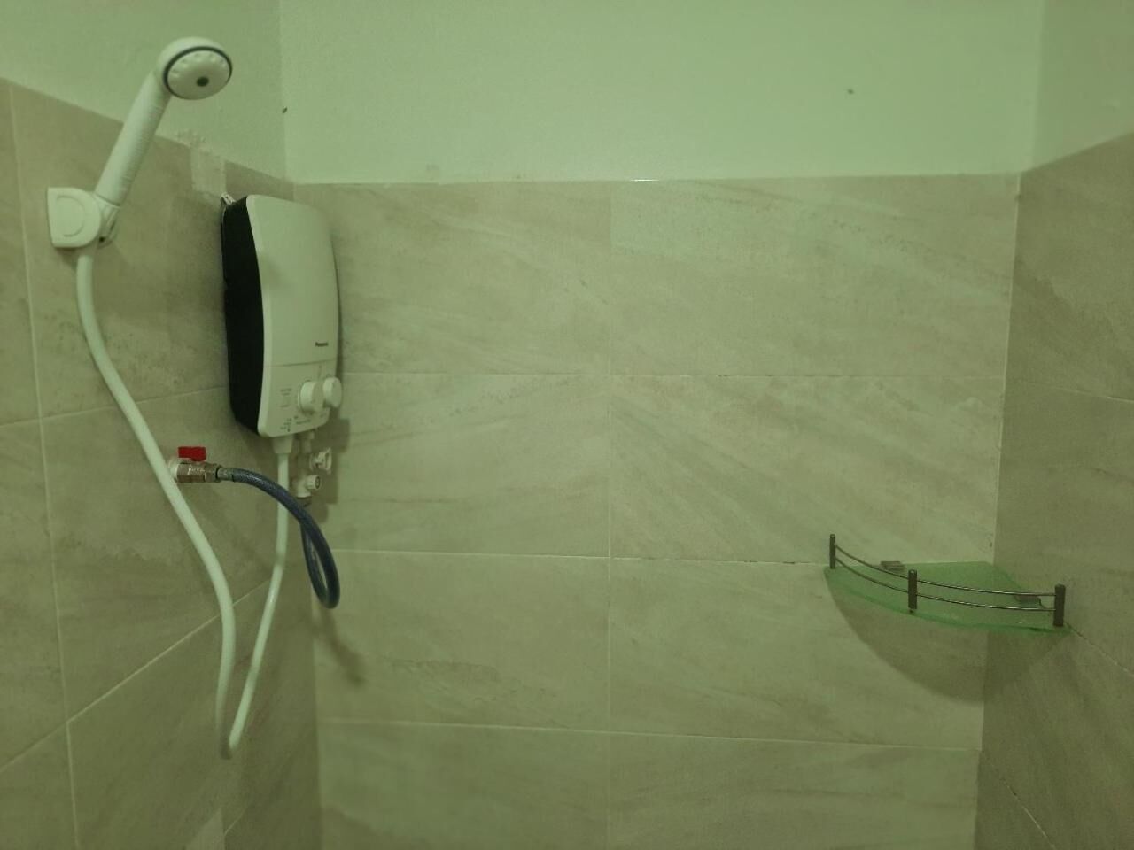 A bathroom with a shower, a towel rack, and a hand dryer.