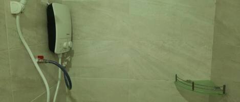 A bathroom with a shower, a towel rack, and a hand dryer.