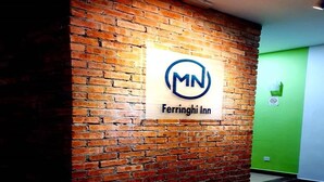 A brick wall with a sign for Ferrirngi Inn. - MN Ferringhi Inn (George Town)