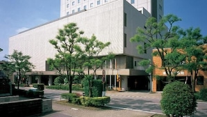 Un hôtel moderne, caractérisé par une structure haute et rectangulaire ainsi qu’un toit plat.
