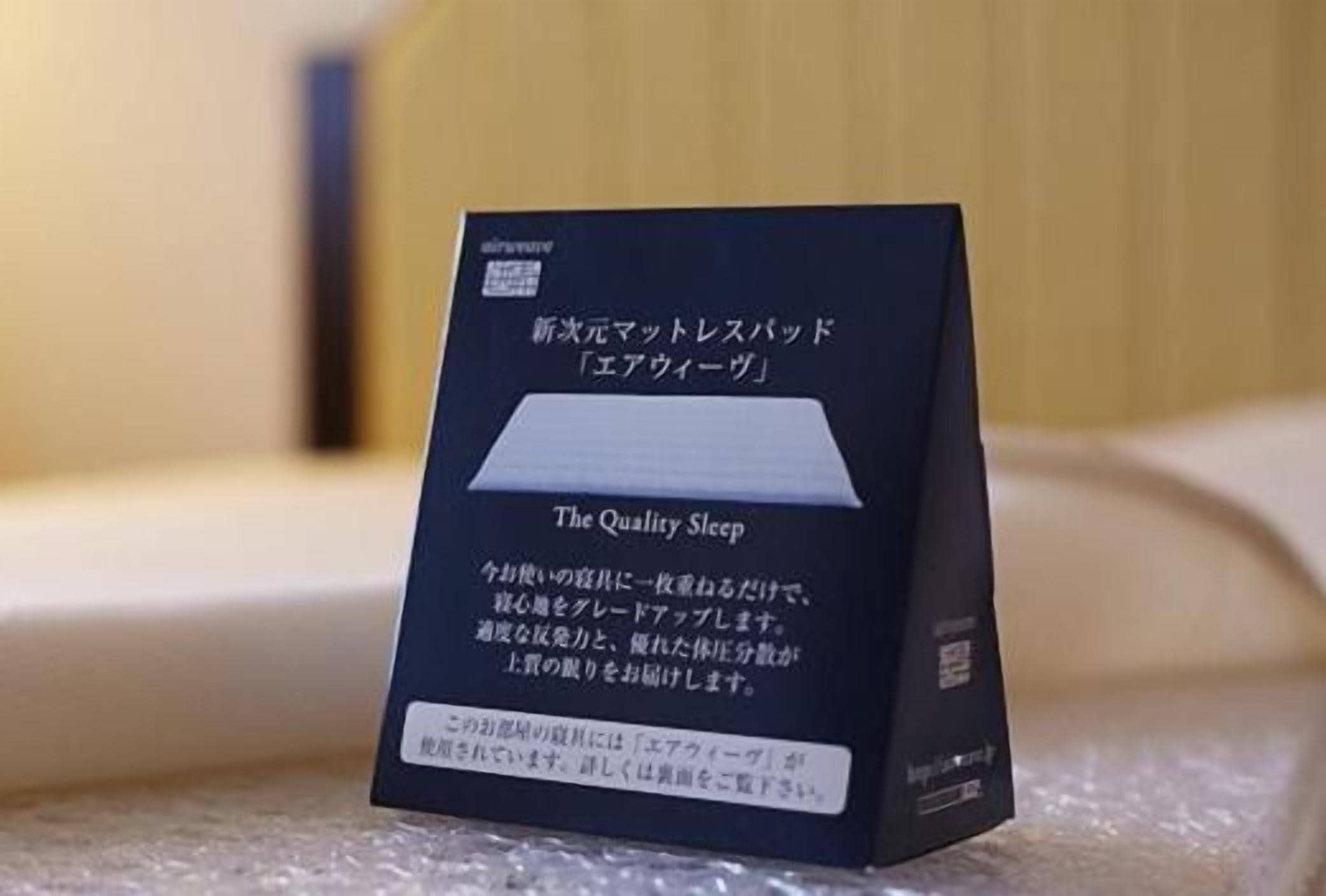 A box labeled "The Quality Sleep airwave" with Japanese text and a pillow with the same branding.