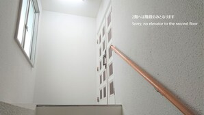 Una escalera con barandilla de metal y una puerta con paneles de vidrio.
