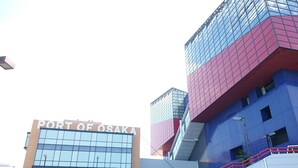 Un edificio con un letrero que dice "PORT OF OSAKA" y una escalera adornada con murales coloridos.