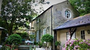 A stone building with a covered patio area, outdoor seating, and potted plants. - Rural retreat in Hertfordshire near the idyllic medieval village of Ashwell   (Ashwell)