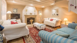 A cozy living room with a fireplace, two sofas, a coffee table, and a patterned rug. - Rural retreat in Hertfordshire near the idyllic medieval village of Ashwell   (Ashwell)