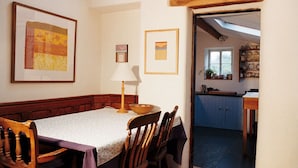 Un comedor con una mesa dispuesta para cuatro, una lámpara y obras de arte enmarcadas en la pared.