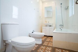 Bathtub, hair dryer, towels, toilet paper