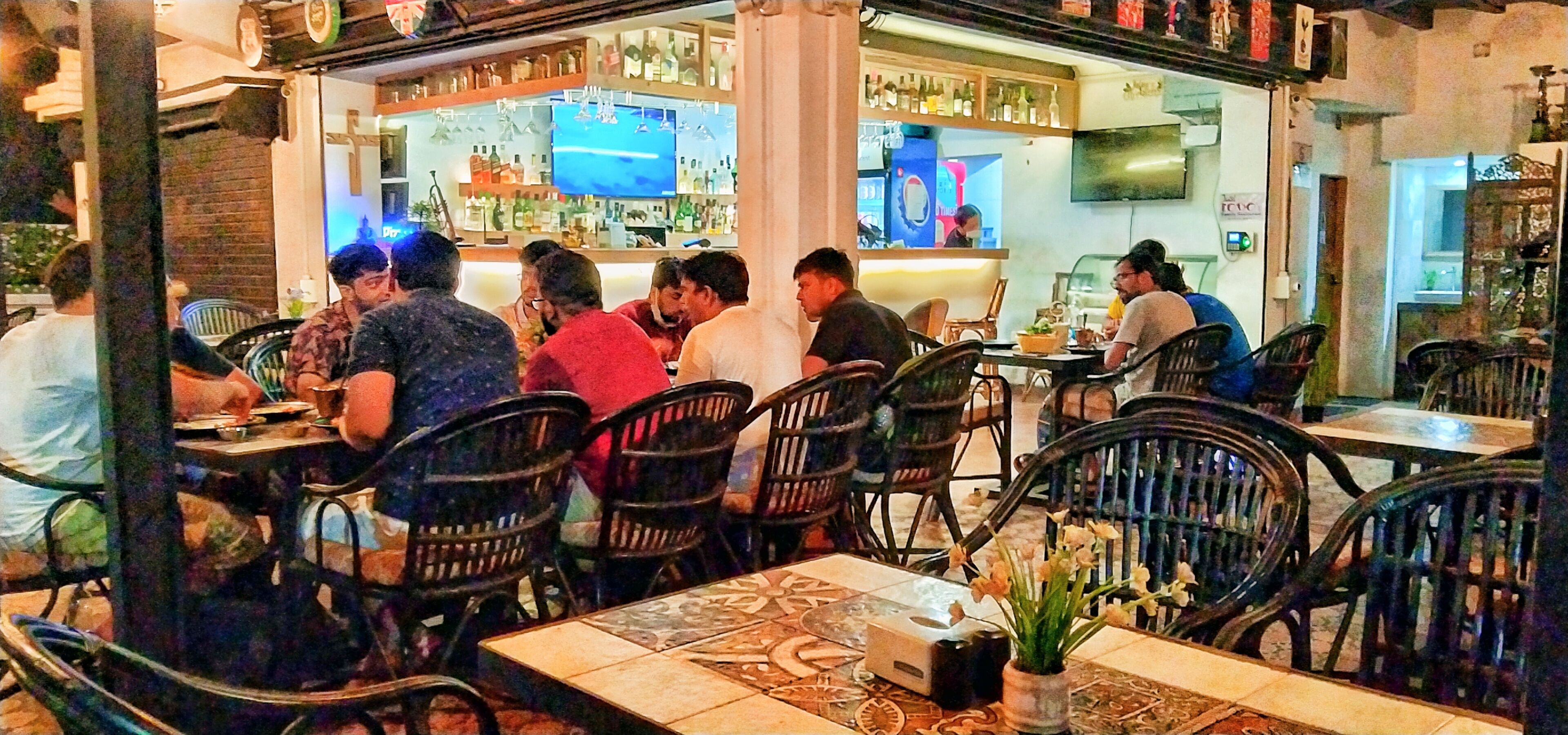 Un restaurant doté d’une terrasse, d’un bar et d’un écran de télévision.
