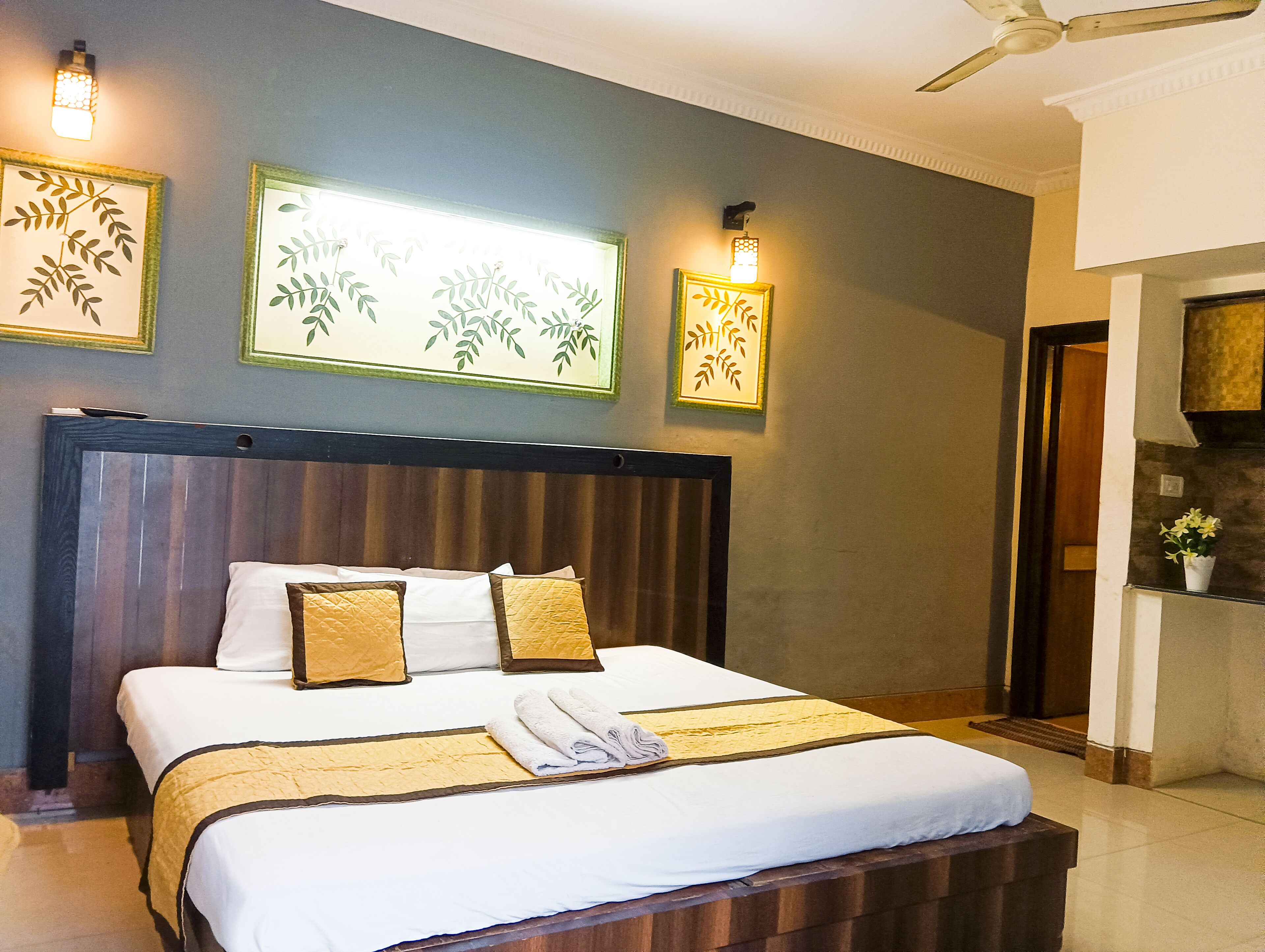 Een hotelkamer met een groot bed, een houten hoofdbord en wandlampen.