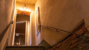 Eine Treppe mit einer Steinwand an der Seite und einer Holztür oben.
