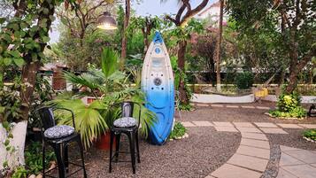 Ein Gartenbereich mit einer blauen Skulptur, zwei Stühlen und einer Hängematte.