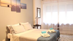 A bedroom with a bed, two bedside tables, a lamp, and a window with curtains. - The easiest way to enjoy Rome (Roma)