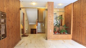A wooden interior with a marble floor, a staircase, and a potted plant. - The easiest way to enjoy Rome (Roma)
