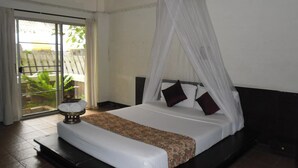 A bedroom with a bed, a canopy, a nightstand, and a view of the outdoors. - Baan Pim (Chiang Mai)