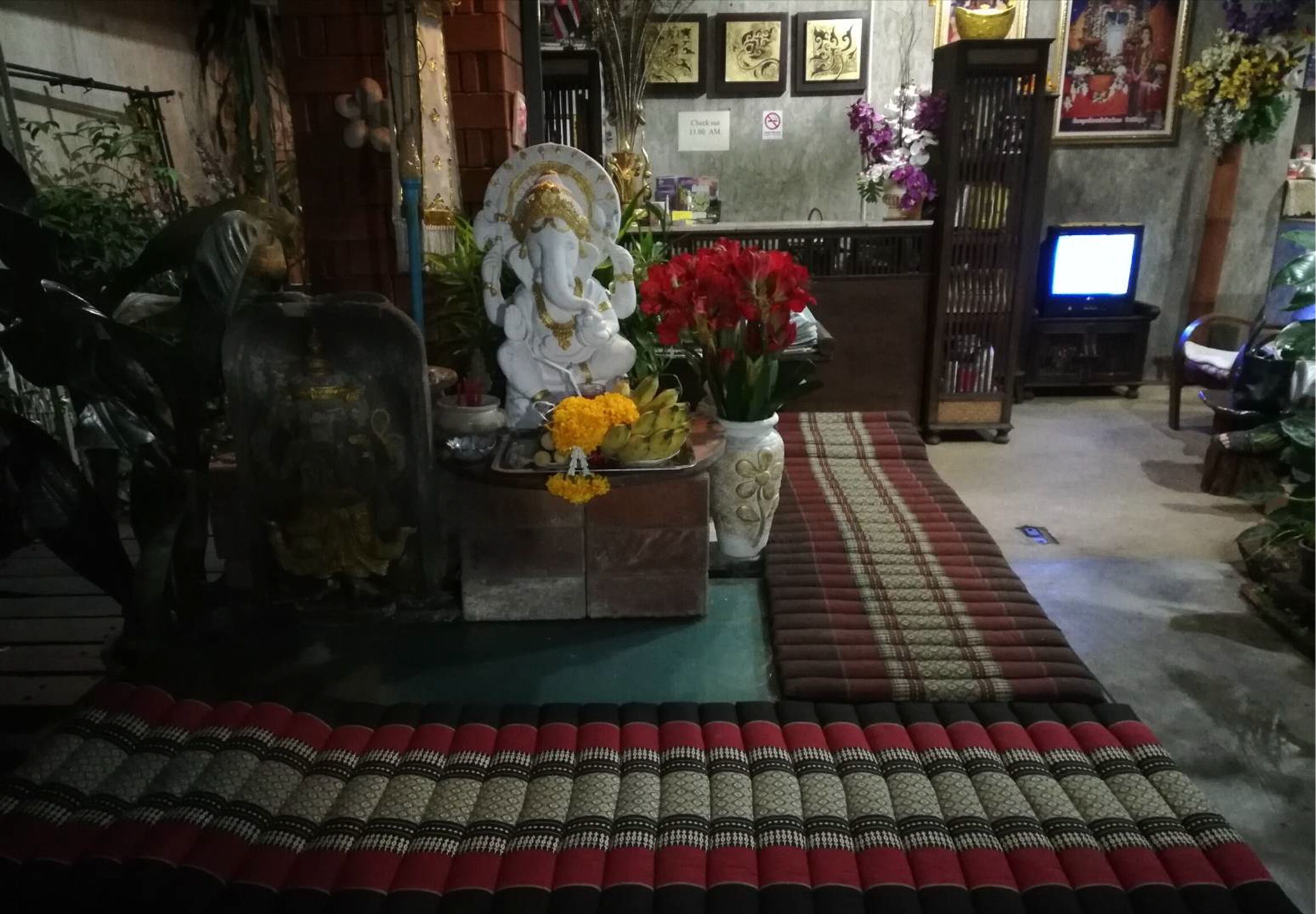 A room with a reception desk, a statue, and a television.