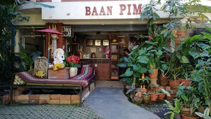 A storefront named "BAAN PIM" with a variety of plants and religious statues outside. - Baan Pim (Chiang Mai)