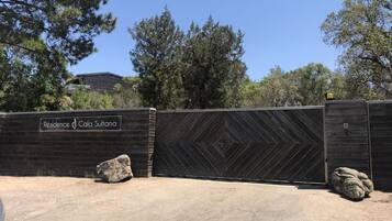 Una entrada cerrada con un cartel que dice 'Résidence Cala Sultana' y una valla de madera con un diseño geométrico.