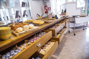 A buffet with various food items and a fire extinguisher on the wall. - Casa Portofino Rooms&Breakfast (Cesenatico)