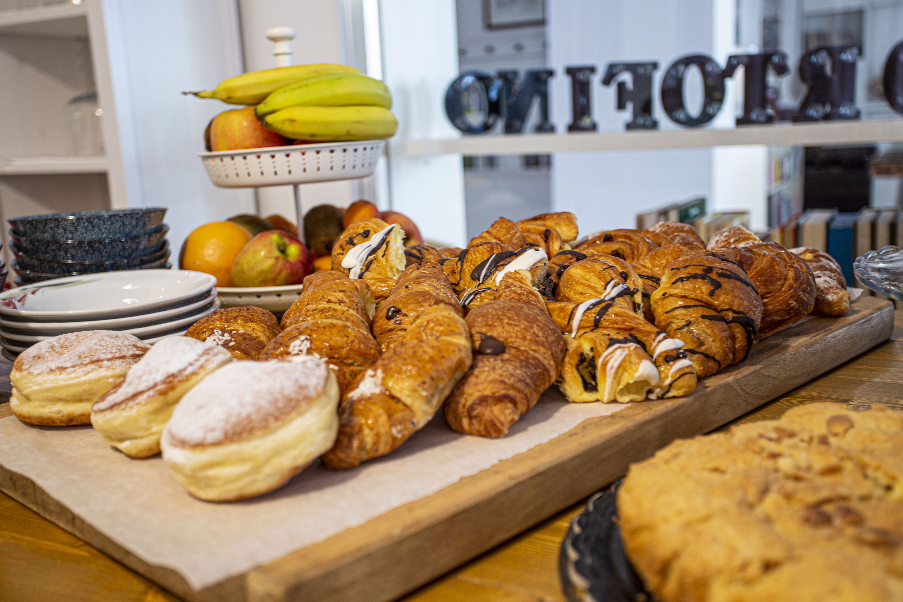Eine Auswahl an Gebäck und Früchten, darunter Croissants und Bananen.
