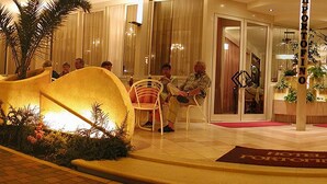 A hotel lobby with a reception desk, seating area, and a staircase leading to the upper floors. - Casa Portofino Rooms&Breakfast (Cesenatico)