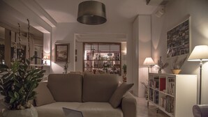 A living room with a sofa, a coffee table, a bookshelf, and a lamp. - Casa Portofino Rooms&Breakfast (Cesenatico)