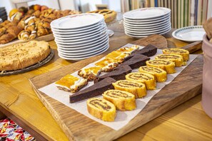 A wooden table with various desserts and plates. - Casa Portofino Rooms&Breakfast (Cesenatico)