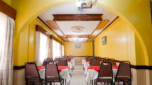 A dining hall with tables and chairs arranged in rows, a chandelier, and a framed picture on the wall. - Midview Hotel Nairobi (Nairobi)