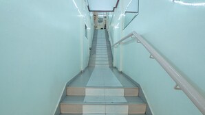 A staircase with a handrail, leading to a landing with a door and a light fixture. - Midview Hotel Nairobi (Nairobi)