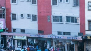 A multi-story building with a central entrance, several ground-level shops, and a visible hotel sign. - Midview Hotel Nairobi (Nairobi)
