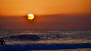 A sunset over the ocean with waves and a silhouette of a person. - Villa Irene - Amazing Villa with private pool near beach and golf course (Almancil)