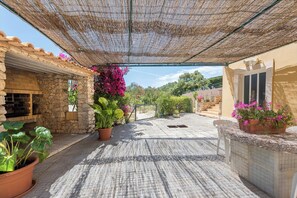 Un patio cubierto con paredes de piedra, plantas en macetas y suelo de ladrillo.
