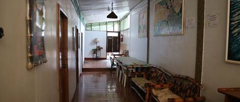 Un pasillo con comedor que incluye una mesa, sillas, una lámpara colgante y un mural en la pared.