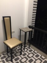 Una silla y una mesita en una habitación con suelo estampado.